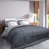 A bed with pillows and a comforter in a room with blinds. Voir les images du produit