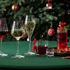 A festive table setting with various drinks and a Christmas tree in the background. Náhled obrázku produktu