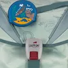 Close-up of a backpack strap buckle and a decorative patch. Produktbild-Vorschau