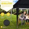 An elderly man and a young girl sitting on a bench under a black pop-up gazebo in a garden, with rain falling. Anteprima dell’immagine prodotto