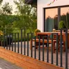 A modern deck with a black metal railing and outdoor furniture. Náhled obrázku produktu