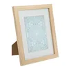 A wooden picture frame with a white mat and a patterned insert. Produktbild-Vorschau