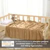 A beige fleece blanket is laid out on a child's bed, with a teddy bear and pillow. Náhľad obrázku produktu