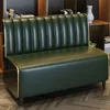 A green sofa in a room with bookshelves and a vase. Anteprima dell’immagine prodotto