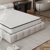 A bedroom scene with a mattress on a bed frame, a desk, and a bathtub in the background. Produktbild-Vorschau