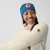 A woman wearing a cream turtleneck sweater and a blue headband. Produktbild-Vorschau