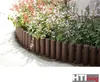 A garden bed with flowers and a brown wooden border. Produktbild-Vorschau