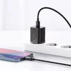 A black USB-C charger plugged into a white power strip, with a black cable connecting it to a smartphone. Produktbild-Vorschau