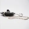 A close-up shot of a drain plug with a metal ball chain, set against a white background. Produktbild-Vorschau