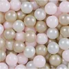 A close-up view of many small, round balls in various shades of pink, beige, and white, tightly packed together. Produktbild-Vorschau