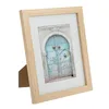 A wooden picture frame with a white mat and a picture of a blue door. Produktbild-Vorschau