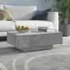 A modern living room setting with a white sofa, a concrete-effect coffee table, and a potted plant. Náhľad obrázku produktu