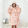 A woman wearing a pink hoodie blanket with a rabbit pattern. Náhled obrázku produktu