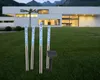 Four solar-powered garden lights with blue bubble effects are placed in a grassy yard in front of a modern white house at dusk. Produktbild-Vorschau