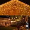 Outdoor scene at night with houses and trees decorated with string lights. Produktbild-Vorschau
