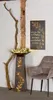 A decorative metal stand with a floral design and a quote, placed next to a wooden beam and a chair. Produktbild-Vorschau