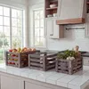 Three wooden crates filled with fruits and herbs are displayed on a kitchen counter. Náhled obrázku produktu