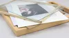 A disassembled picture frame with a photo and matting inside, laid out on a wooden frame. Produktbild-Vorschau