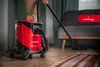 A person is vacuuming a room with a red and black LEHMANN industrial vacuum cleaner. Náhľad obrázku produktu