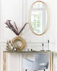 A console table with decorative items and a chair in front of a wall with a mirror. Náhled obrázku produktu