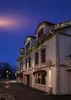 A building decorated with Christmas lights at dusk. Produktbild-Vorschau