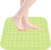 A person's feet standing on a green bath mat. Produktbild-Vorschau