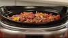 A close-up shot of a slow cooker filled with ingredients. Produktbild-Vorschau