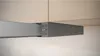 A close-up view of a modern range hood mounted under kitchen cabinets, showing the control panel. Produktbild-Vorschau
