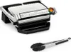 A Tefal Optigrill+ electric grill and a pair of tongs are shown against a white background. Voir les images du produit