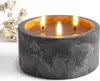 A three-wick LED candle in a concrete-look holder, with a sprig of white flowers in the background. Anteprima dell’immagine prodotto