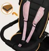 Close-up of a stroller seat with safety harness and a diagram showing material layers. Produktbild-Vorschau