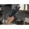 A hand is holding a cordless vacuum cleaner and cleaning a shelf. Produktbild-Vorschau