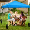 People enjoying a meal under a blue canopy tent in a backyard. Produktbild-Vorschau