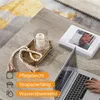 A close-up view of a coffee table with a laptop, a book, a candle on a tray, and decorative beads. Produktbild-Vorschau