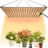 A grow light illuminates several potted plants.