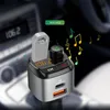 A car FM transmitter with USB ports and a USB drive plugged in, shown in a car's interior. Podgląd zdjęcia produktu