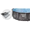A round swimming pool with a wood-like exterior, filled with water. A close-up inset shows the layered material of the pool wall. Anteprima dell’immagine prodotto