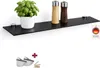 A black glass shelf mounted on a white wall, displaying a potted plant and two spice grinders. Below the shelf, there are mounting brackets and screws. Produktbild-Vorschau