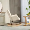 A beige rocking chair is placed in a living room setting, next to a wooden side table and a tall plant. Produktbild-Vorschau