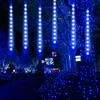 A pathway lined with trees decorated with blue LED lights at night. Produktbild-Vorschau