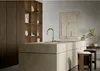 A modern kitchen island with a sink and faucet, featuring a minimalist design with wooden shelving and a piece of abstract art on the wall. Produktbild-Vorschau