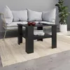 A black coffee table with a shelf is placed on a beige rug in front of a grey sofa. Two red apples and a book are on the table. Voir les images du produit