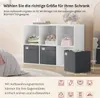 A white cube shelf unit with storage boxes and items inside, next to a bed and a mirror. Produktbild-Vorschau
