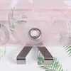 A close-up of a pink sheer curtain with a floral pattern and a metal grommet, held by two metal clips. Produktbild-Vorschau