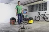 A man is vacuuming a wet concrete floor in a garage with a yellow Karcher wet/dry vacuum. A bicycle and some tires are in the background. Anteprima dell’immagine prodotto