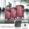 A set of four red suitcases of varying sizes are displayed in an airport terminal. Several people are visible in the background, blurred. Náhled obrázku produktu
