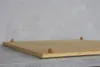 A bamboo cutting board with clear feet sits on a countertop in front of a textured gray wall. Produktbild-Vorschau