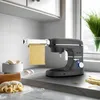 A kitchen counter with a stand mixer and pasta attachment, along with ingredients for making pasta. Produktbild-Vorschau