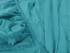A close-up view of a teal-colored fitted sheet, showing the elasticized edge and fabric texture. Produktbild-Vorschau