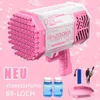 Pink-weiße Bazooka-Blasenpistole mit 69 Löchern, zwei Flaschen Blasenlösung, einem blauen Akku, USB-Ladegerät und pinkem Tauchtablett Voir les images du produit